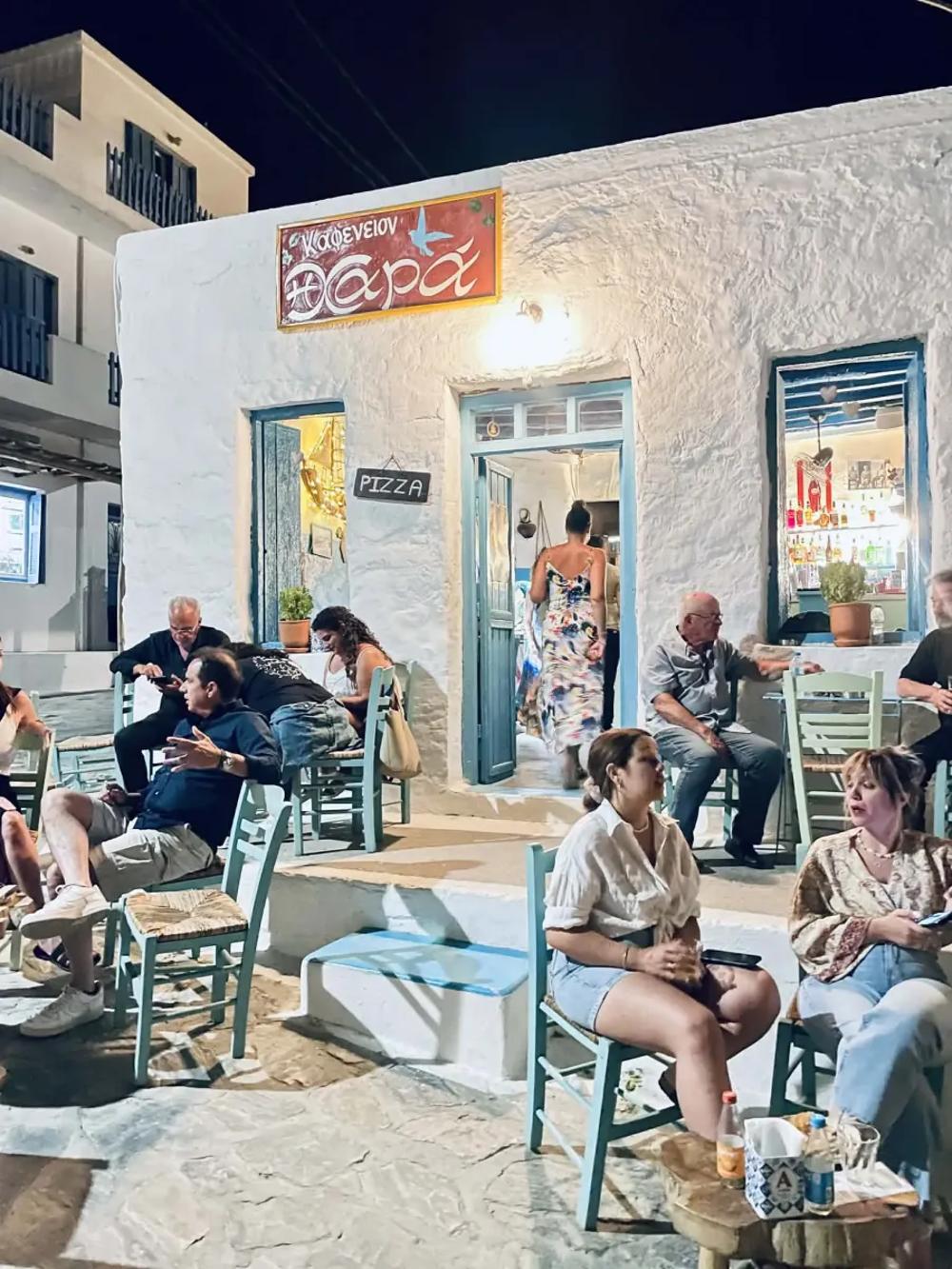 a vibrant evening on a traditional cafe in the Greek islands while staying there for the night during a yacht charter