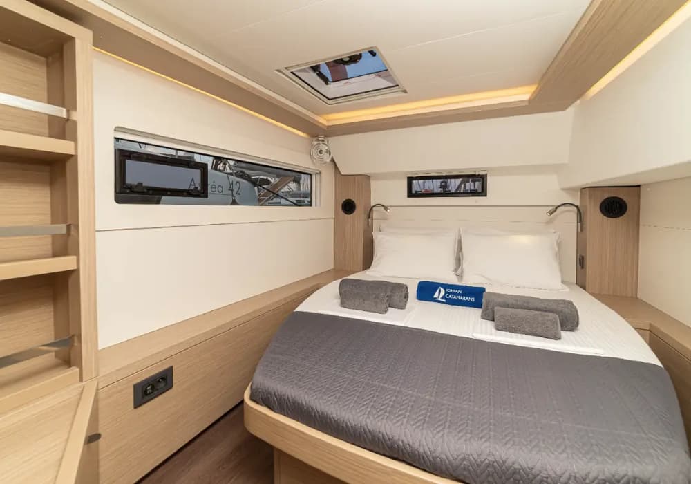 Lagoon 46 review - elegant double cabin with a spacious bed, ambient lighting, and modern interior design for a comfortable sailing experience.