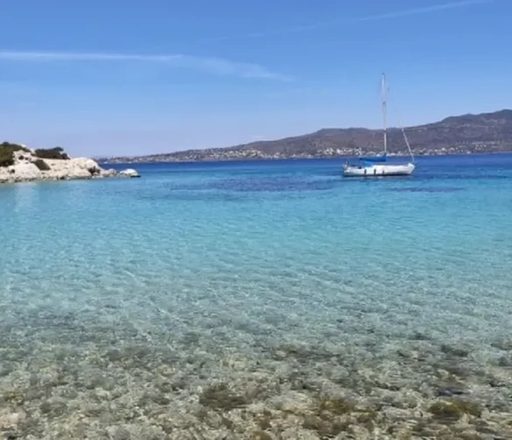 A sailing yacht anchored in serene waters near Athens, an idyllic destination for group holidays."