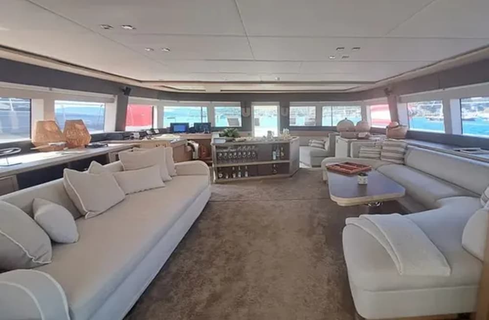 Elegant and spacious interior lounge of the Lagoon 78 catamaran, designed for ultimate comfort with modern furnishings, a stylish bar, and ample seating for guests on luxury sailing holidays.