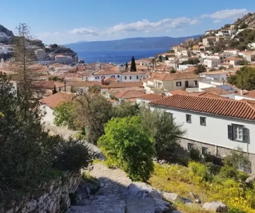 View of Hydra Island's charming rooftops and sea backdrop, ideal for a sailing adventure starting in Athens.