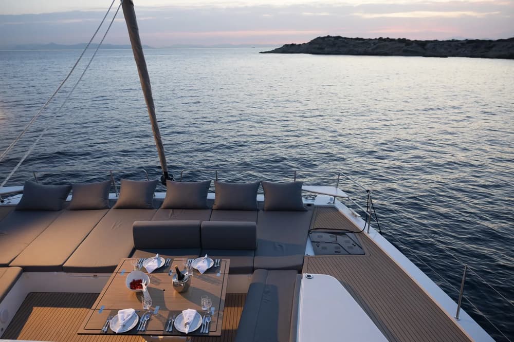 Spacious flybridge lounge and dining area at sunset on board Bali 5.8 catamaran