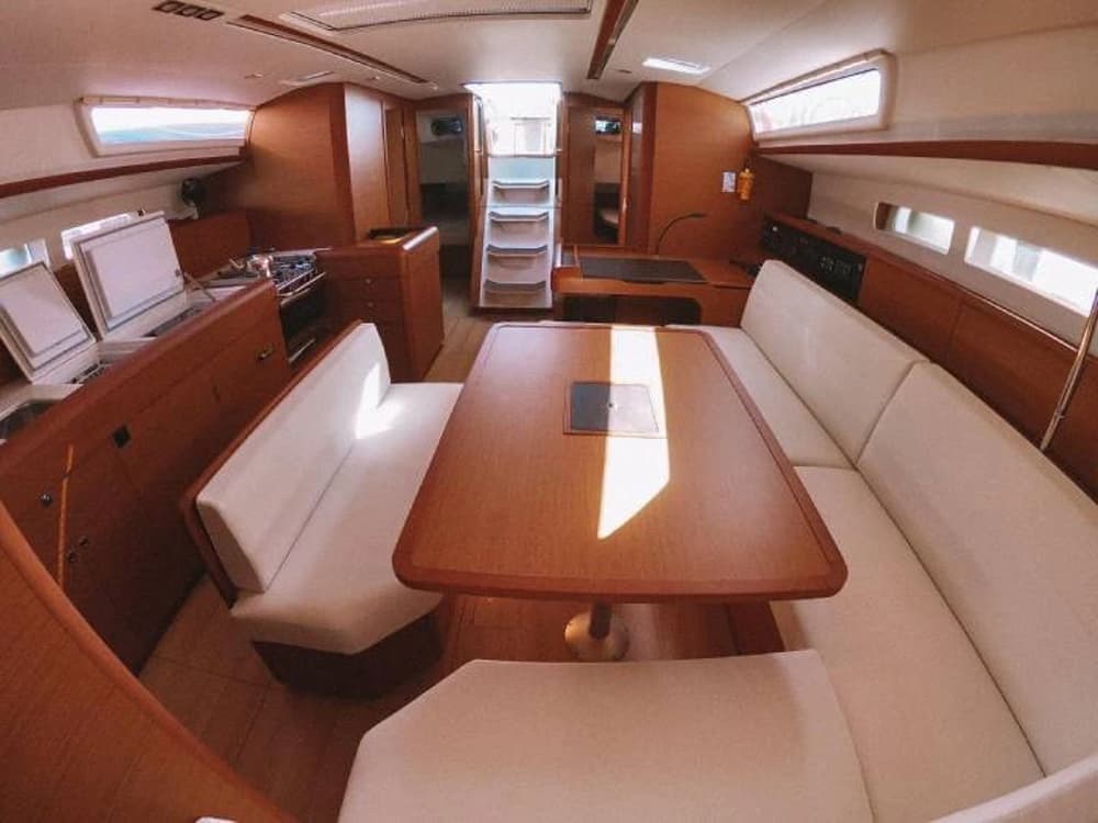 Spacious interior of a premium sailboat featuring a stylish and comfortable dining area, ideal for long sailing holidays.