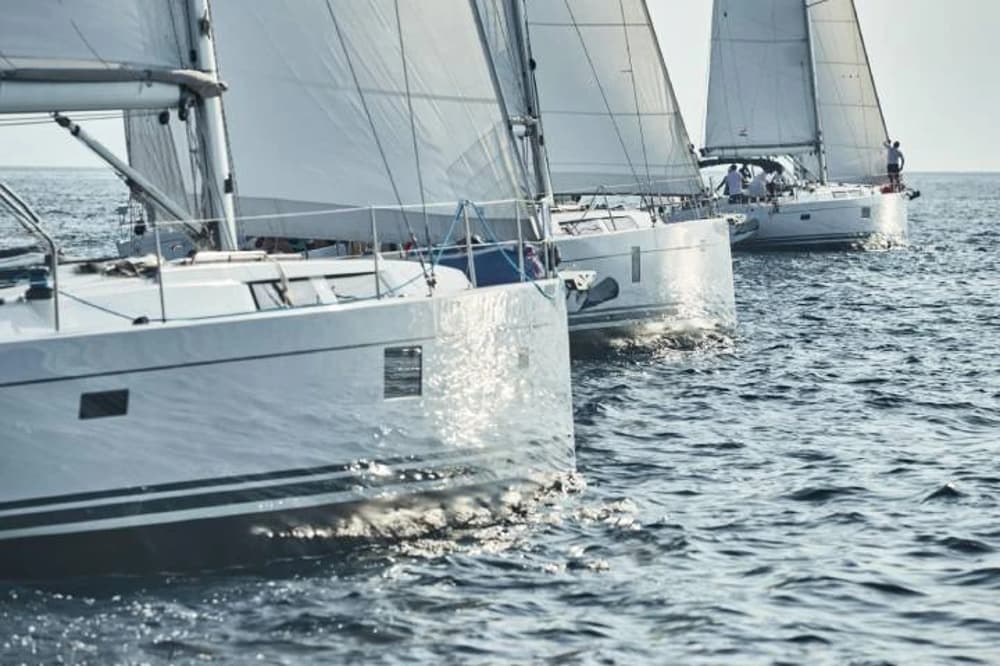 Close-up of sailboats cruising together on the open sea, showcasing top-performing models for charter sailing holidays.