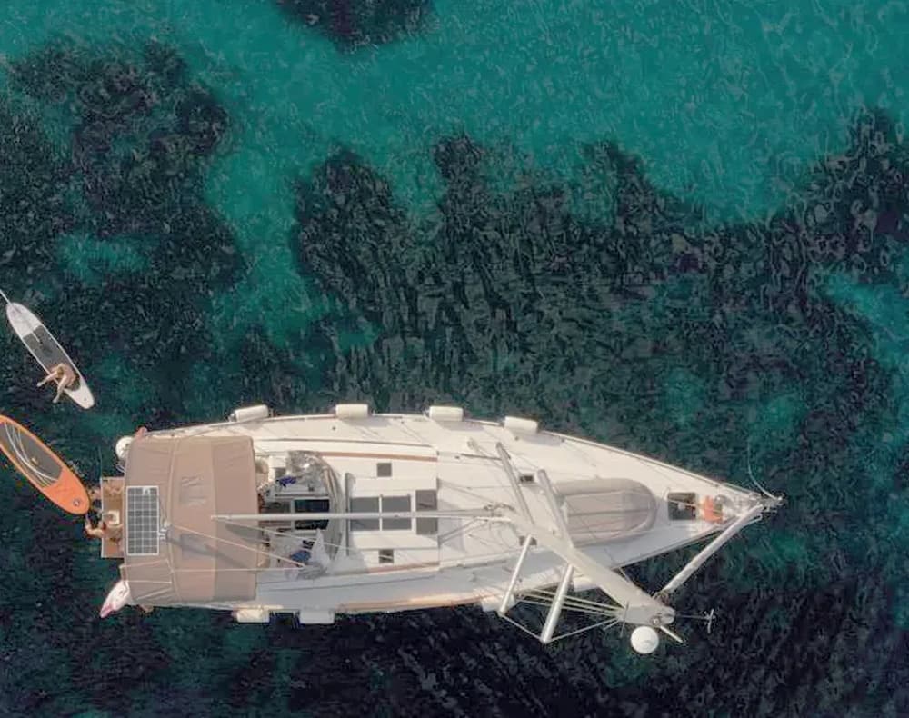 Aerial view of a monohull yacht with water toys, highlighting the sleek design and agility.