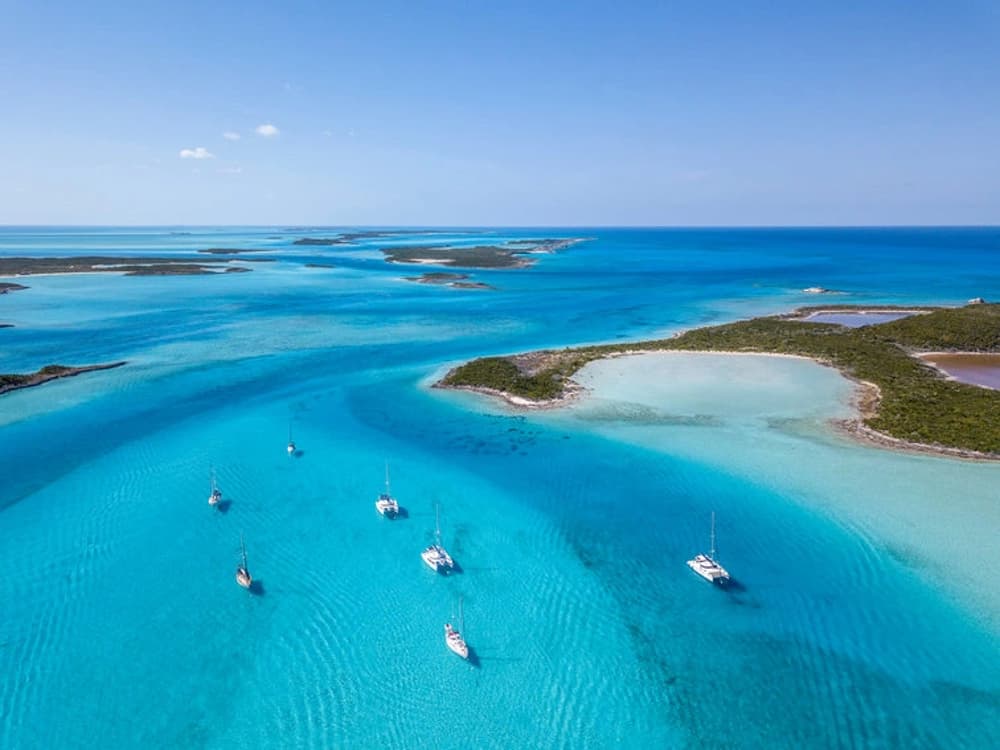 Turquoise waters of the Bahamas with anchored yachts – one of the best sailing destinations for beginners seeking stress-free sailing holidays.