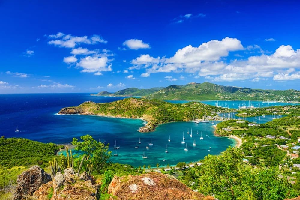 Sailboats in Antigua’s clear waters – an ideal destination for intermediate sailors looking to improve their sailing experience level.