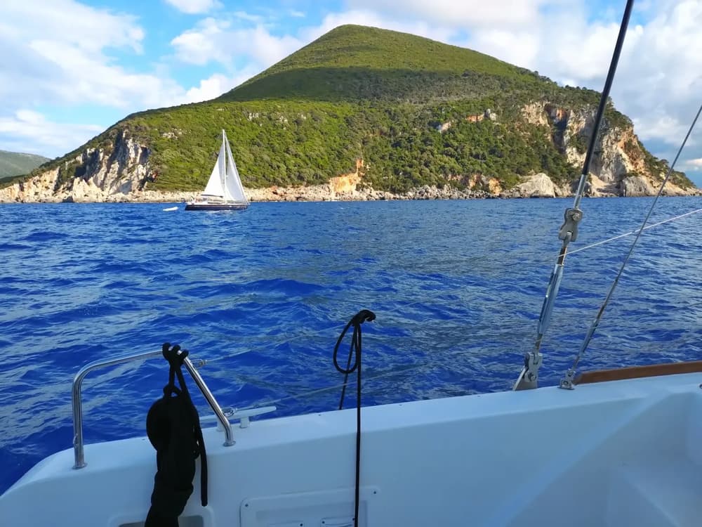 sailing yacht next to a yacht with open sails sailing in Greece