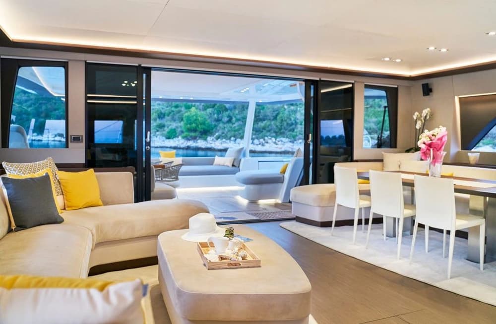 The spacious and modern interior of the Lagoon 77 catamaran, showcasing a sophisticated lounge, dining area, and panoramic windows for ultimate comfort at sea.