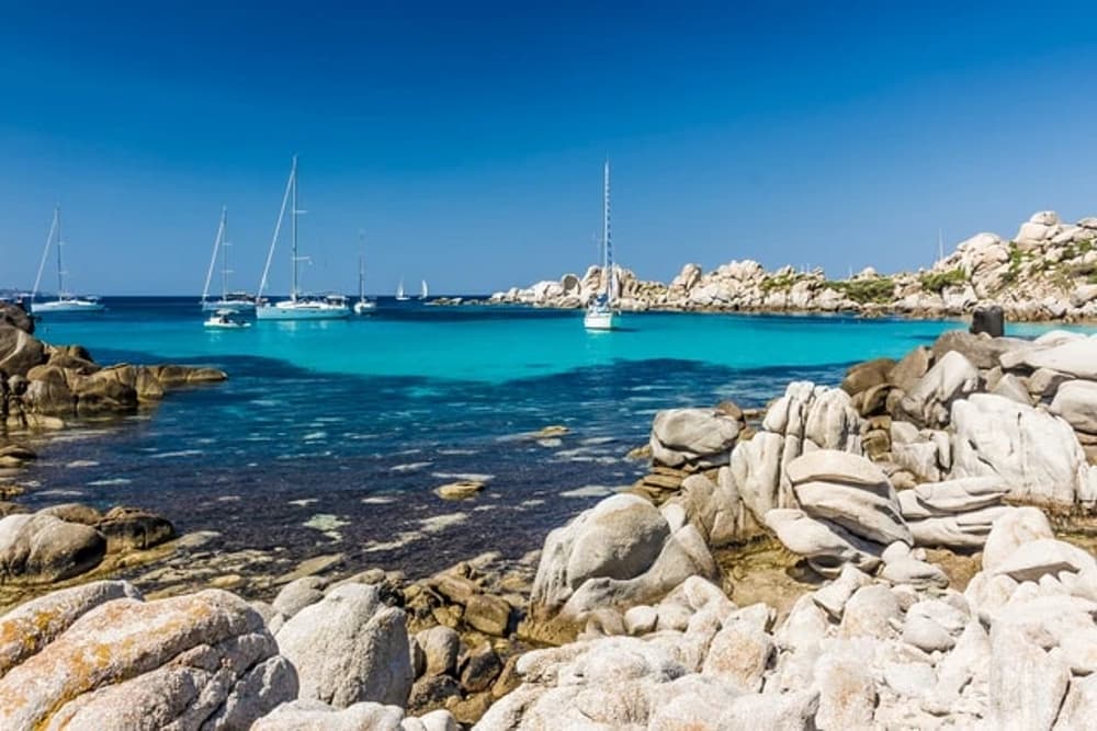 Lavezzi Islands, Corsica – Secluded turquoise bay with anchored sailing yachts, an unmissable stop for yacht charters exploring Corsica and Sardinia.