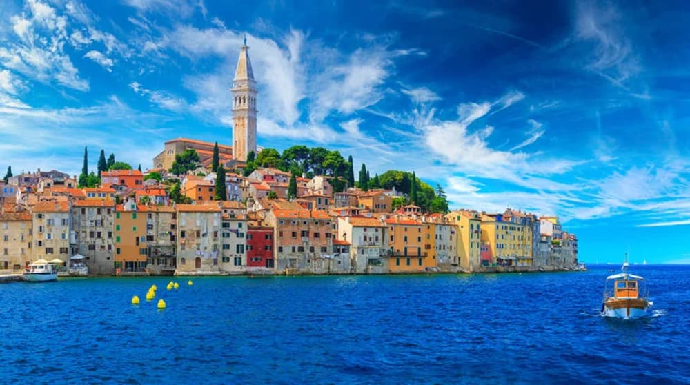 Rovinj's stunning coastal view with colourful houses, a bell tower, and the Adriatic Sea, a popular destination for Croatian sailing holidays.