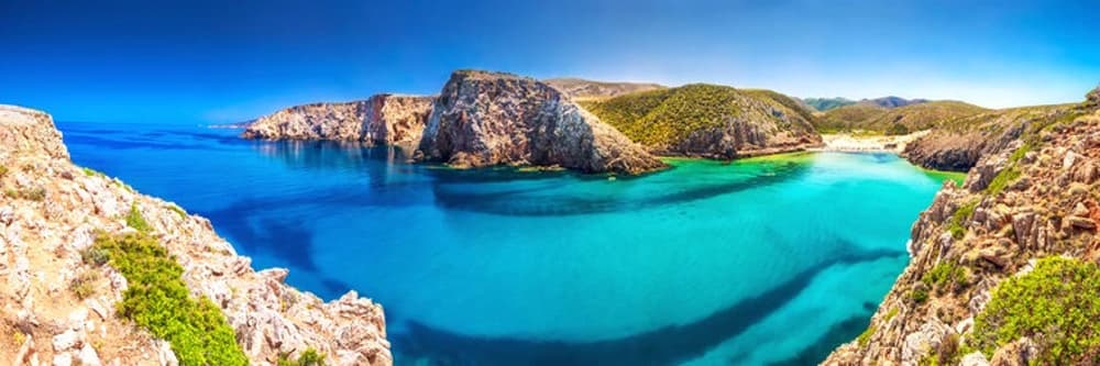 Panoramic view of Sardinia's dramatic cliffs and pristine bays, perfect for an unforgettable sailing holiday in Italy.