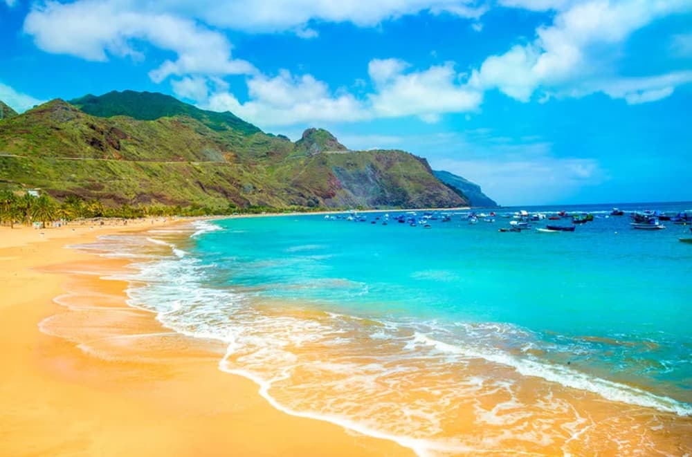 Stunning beach with golden sands and turquoise waters in Tenerife, perfect for sailing holidays in Spain.