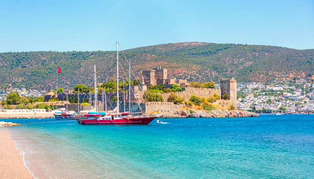 Bodrum Castle and anchored yachts under the sunny skies, a key destination for sailing holidays in Turkey.