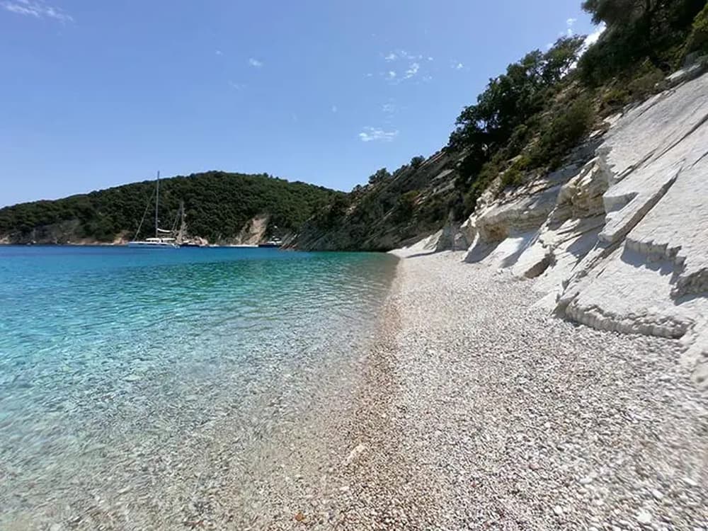 Pristine pebble beach with crystal-clear waters. along the Athens to Corfu sailing route.