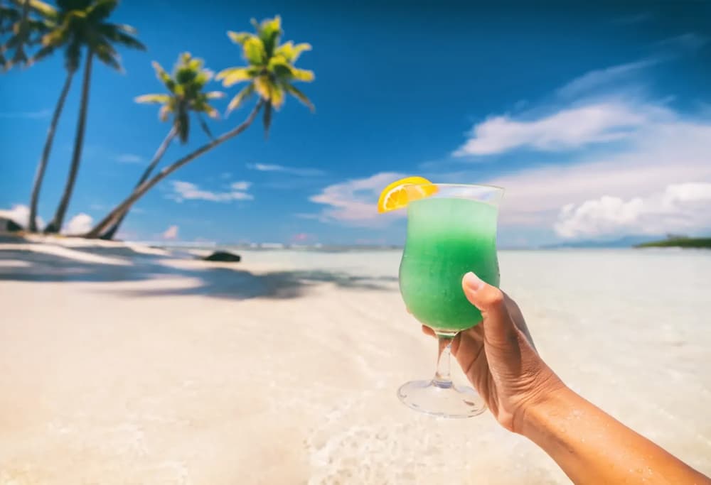Glass raised at a golden beach