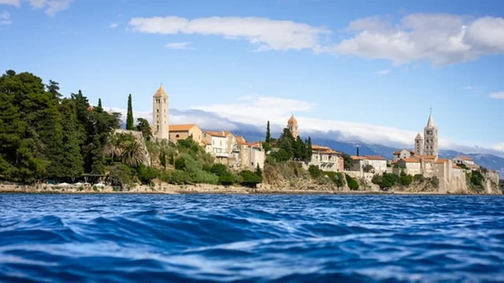 View of Rab, Croatia, from the sea, showcasing its historic skyline and charming architecture – an ideal stop on a Croatian sailing itinerary.