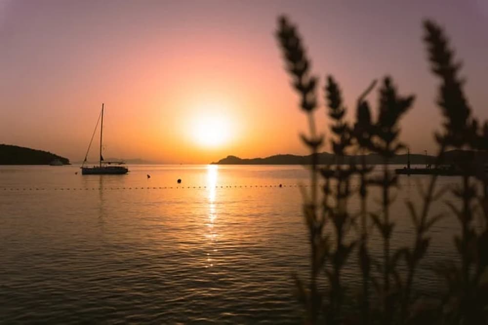 Sailing at sunset in Croatia, a picturesque yacht anchored in the Adriatic Sea with golden hues – perfect for a Croatia yacht charter experience.