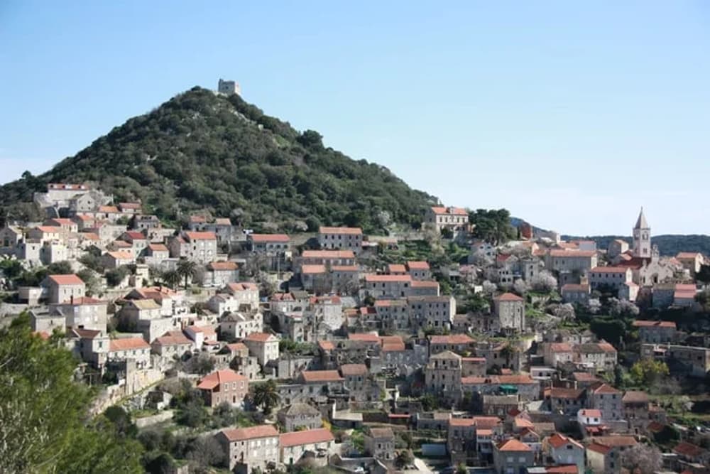 The picturesque town of Vis, Croatia, perched on a hillside with traditional stone houses – a top yacht charter stop for an authentic Adriatic experience.
