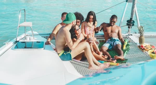 Group of friends enjoying a yacht party near a tropical island, perfect for the best party islands sailing experience.