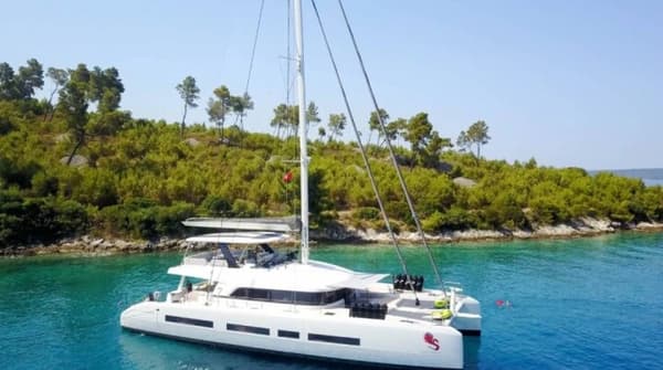 The luxurious Lagoon 77 catamaran sailing in crystal-clear waters, offering spacious decks and premium amenities for an unforgettable yacht charter experience.