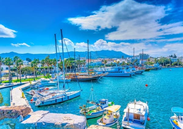 Kos Marina with sailing yachts and gulets docked along the waterfront, a starting point for Greek island sailing holidays. Explore Dodecanese sailing itineraries from Kos, Greece.