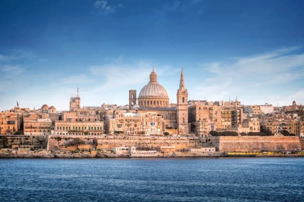 A panoramic view of Valletta's historic waterfront with St. Paul's Cathedral and other architectural landmarks, showcasing the cultural charm of sailing holidays in Malta.
