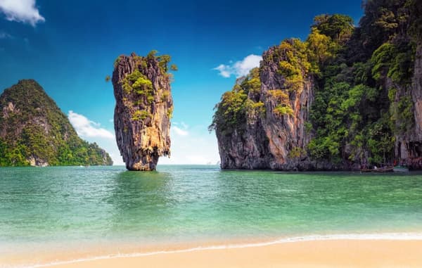 The iconic James Bond Island in Phang Nga Bay, surrounded by turquoise waters, limestone cliffs, and lush greenery, showcasing the stunning landscapes of sailing holidays in Thailand.