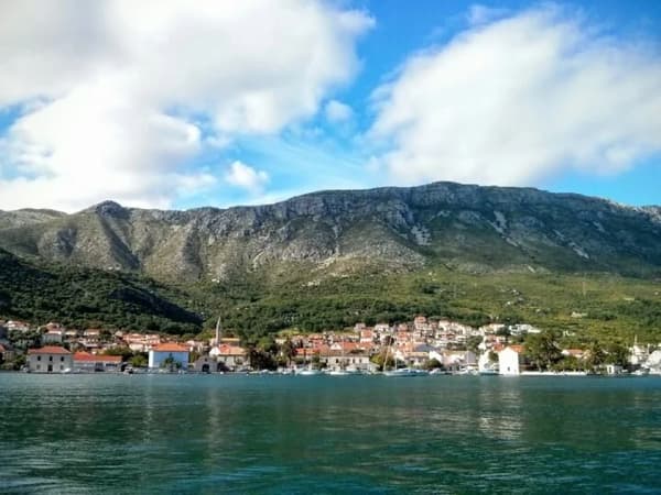Scenic view of the coastal town of Slano, Croatia, framed by mountains and the Adriatic, a must-visit sailing destination along the Dalmatian coast.