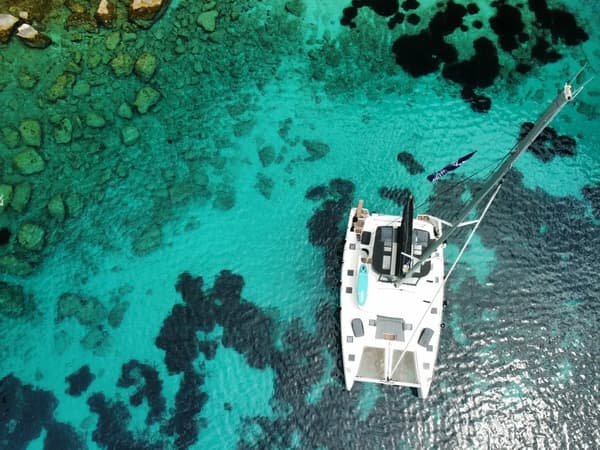 Luxury catamaran charter anchored in crystal-clear turquoise waters of the Mediterranean – Yacht4Less sailing holidays with the best catamaran charter brands.